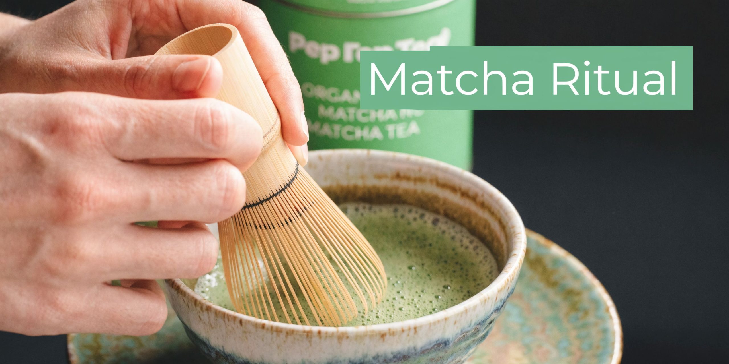 A close-up view of hands whisking traditional green matcha tea in a ceramic bowl with a bamboo whisk.