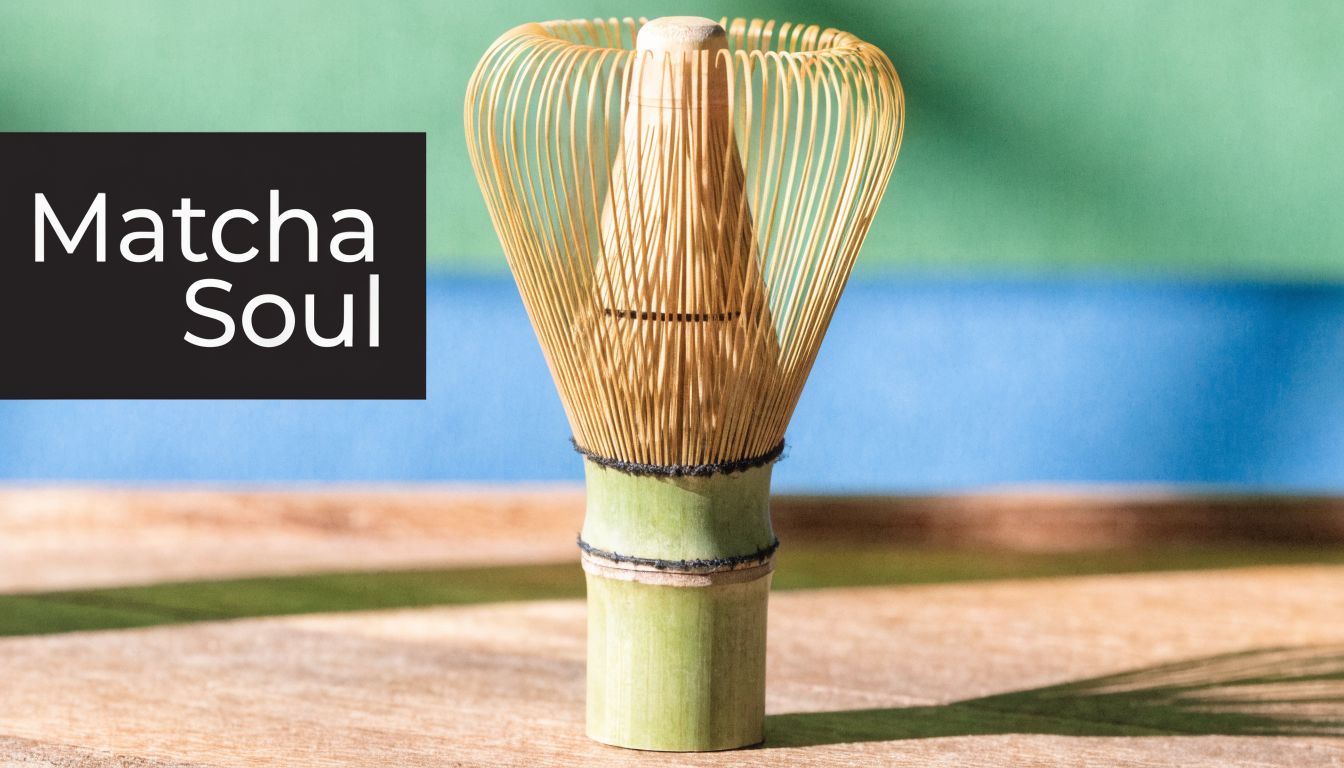 A close up photo of a traditional Japanese bamboo matcha tea whisk resting on a wooden surface.