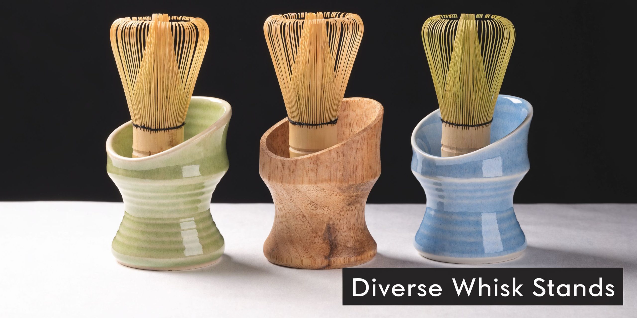 Three different matcha whisk stands in green ceramic, wood, and blue ceramic displayed on a surface.