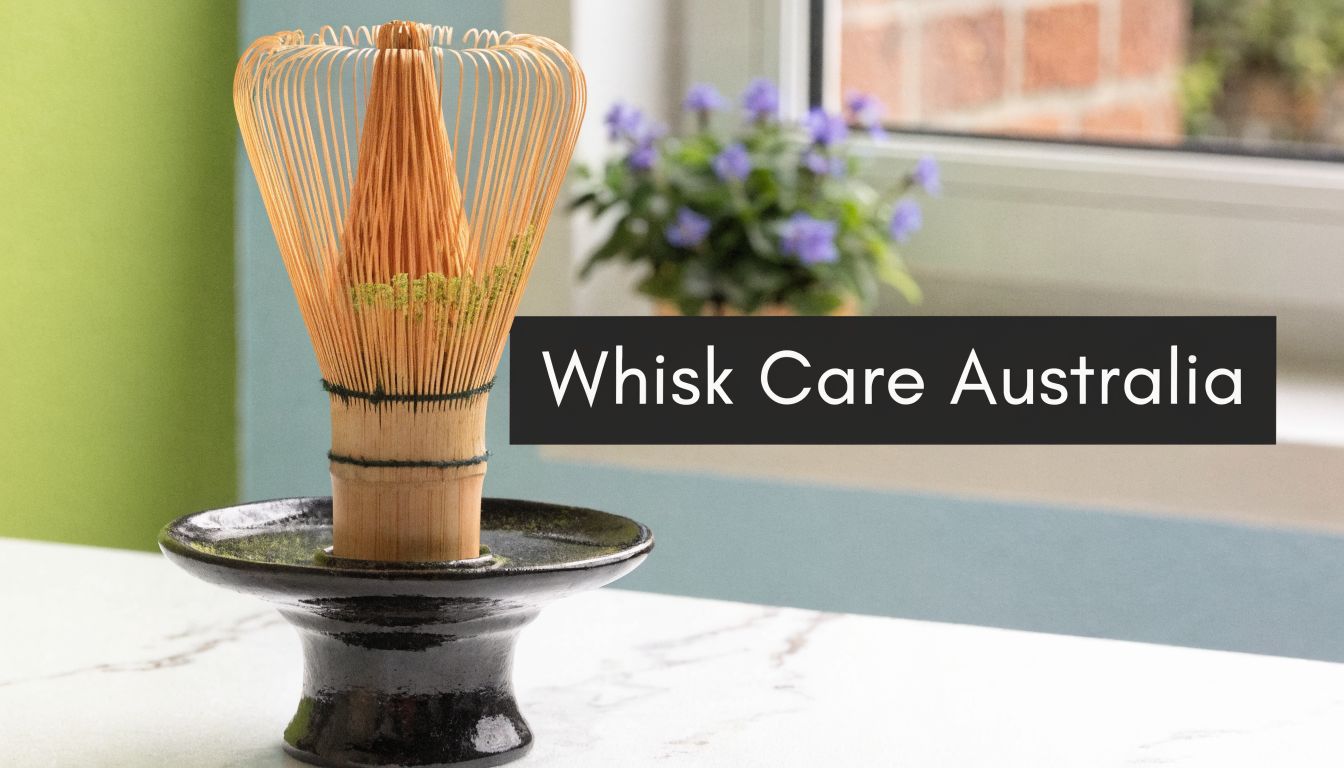 A wooden matcha tea whisk resting on a black ceramic holder against a soft green background.