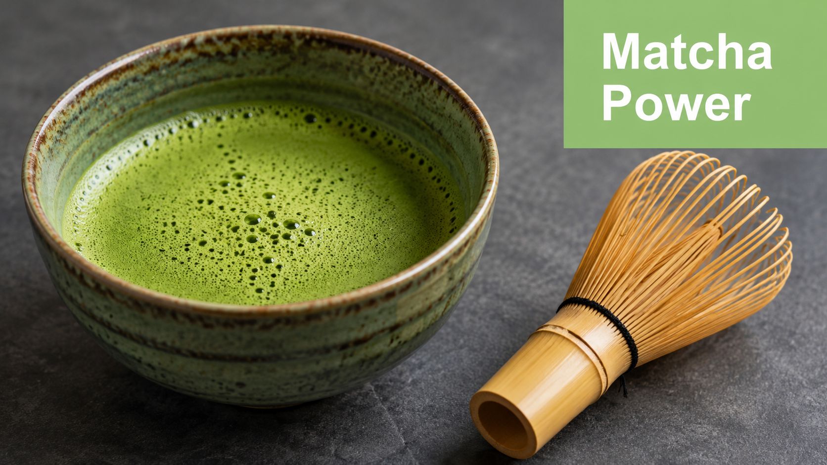 A ceramic bowl filled with bright green matcha tea next to a traditional bamboo whisk.
