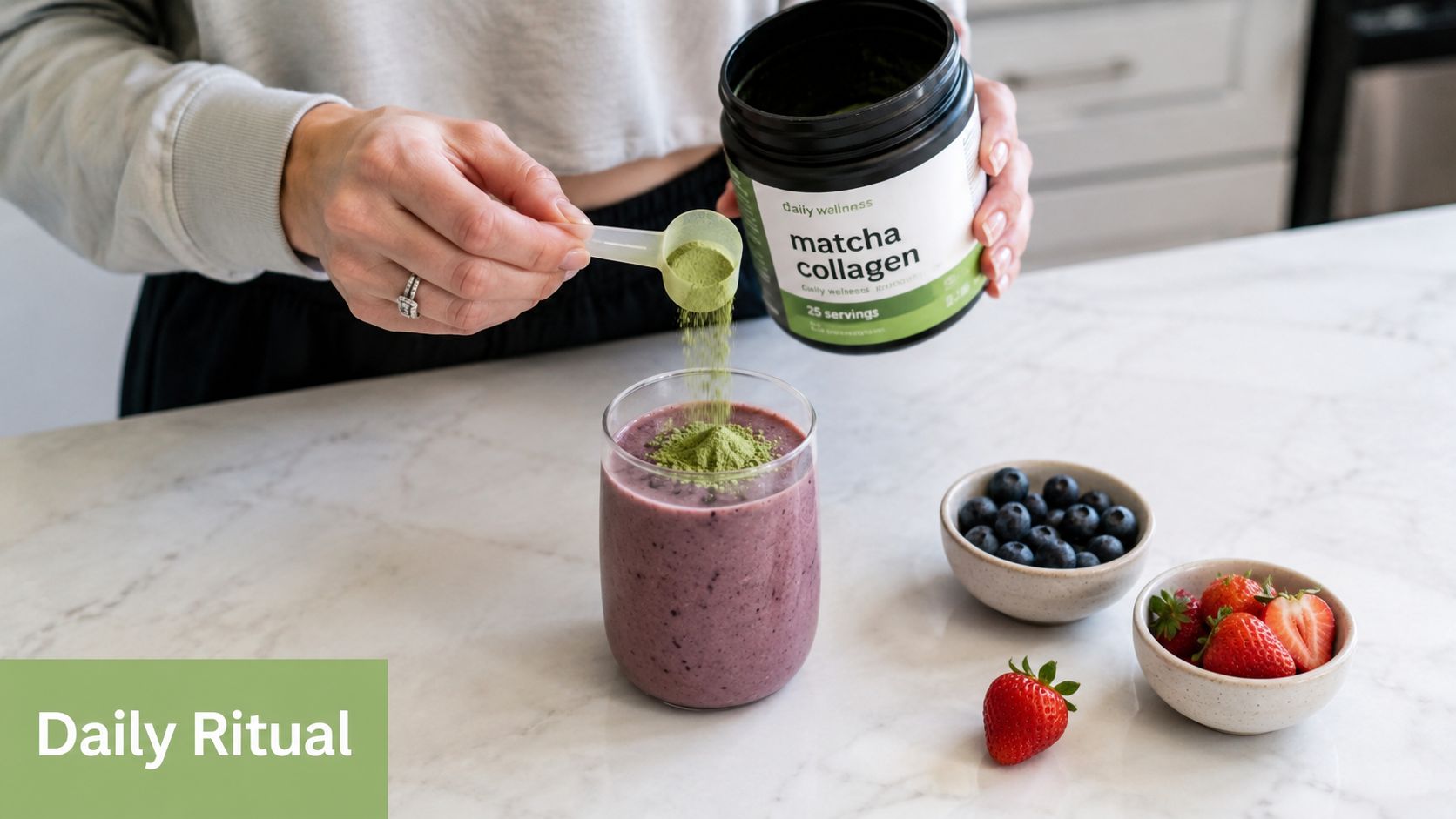 A person adding a scoop of green matcha collagen powder into a purple fruit smoothie in a kitchen.