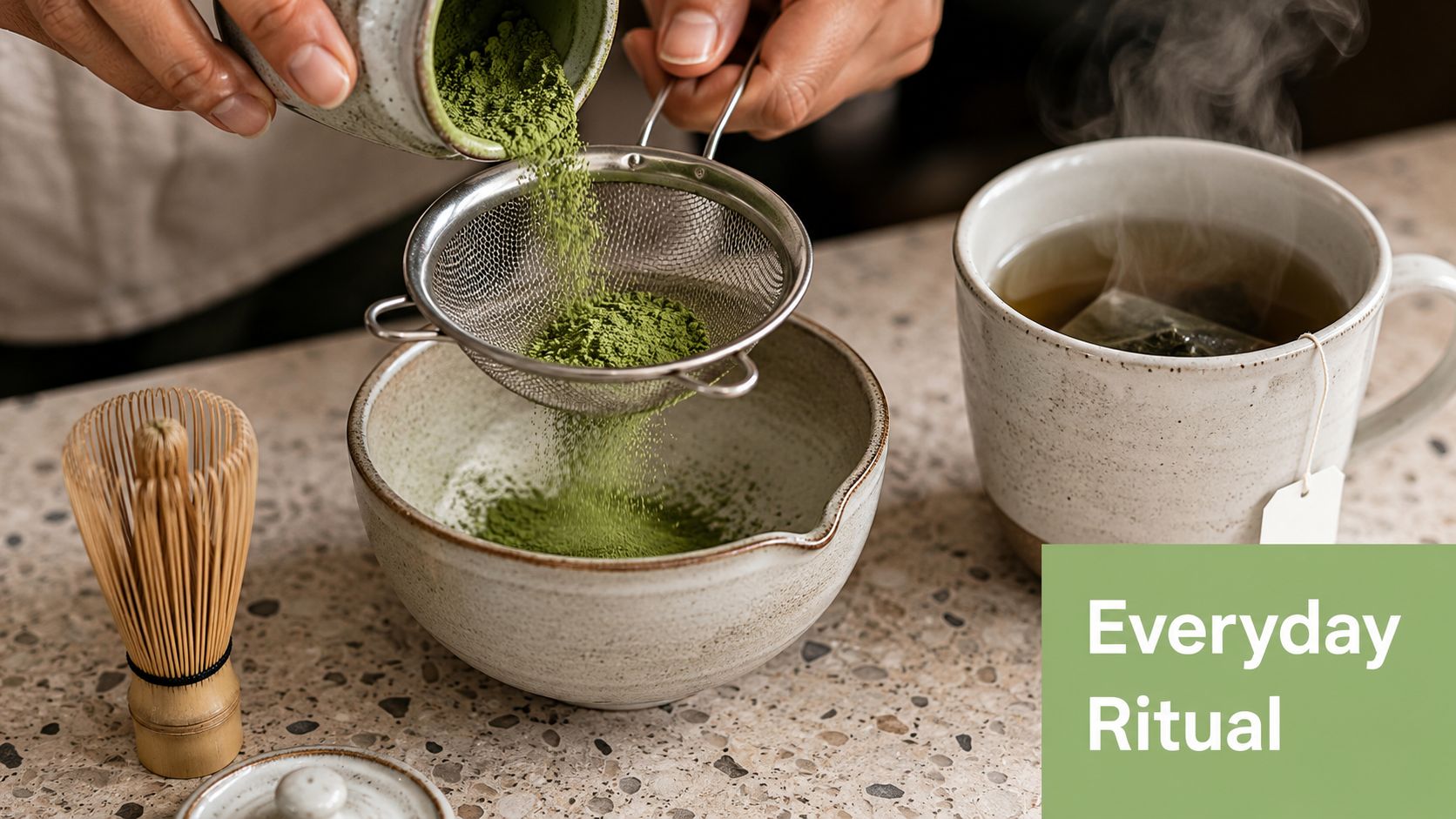 A person sifting matcha powder into a ceramic bowl next to a cup of steaming tea.