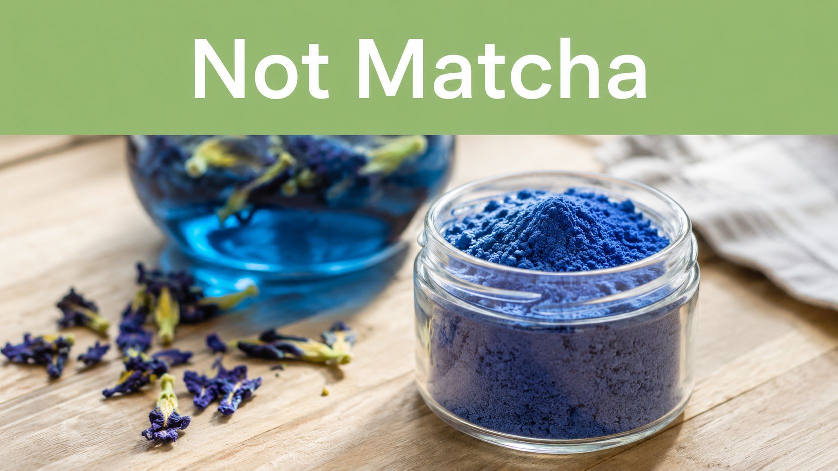 A glass jar filled with vibrant blue butterfly pea flower powder next to dried blue flowers.