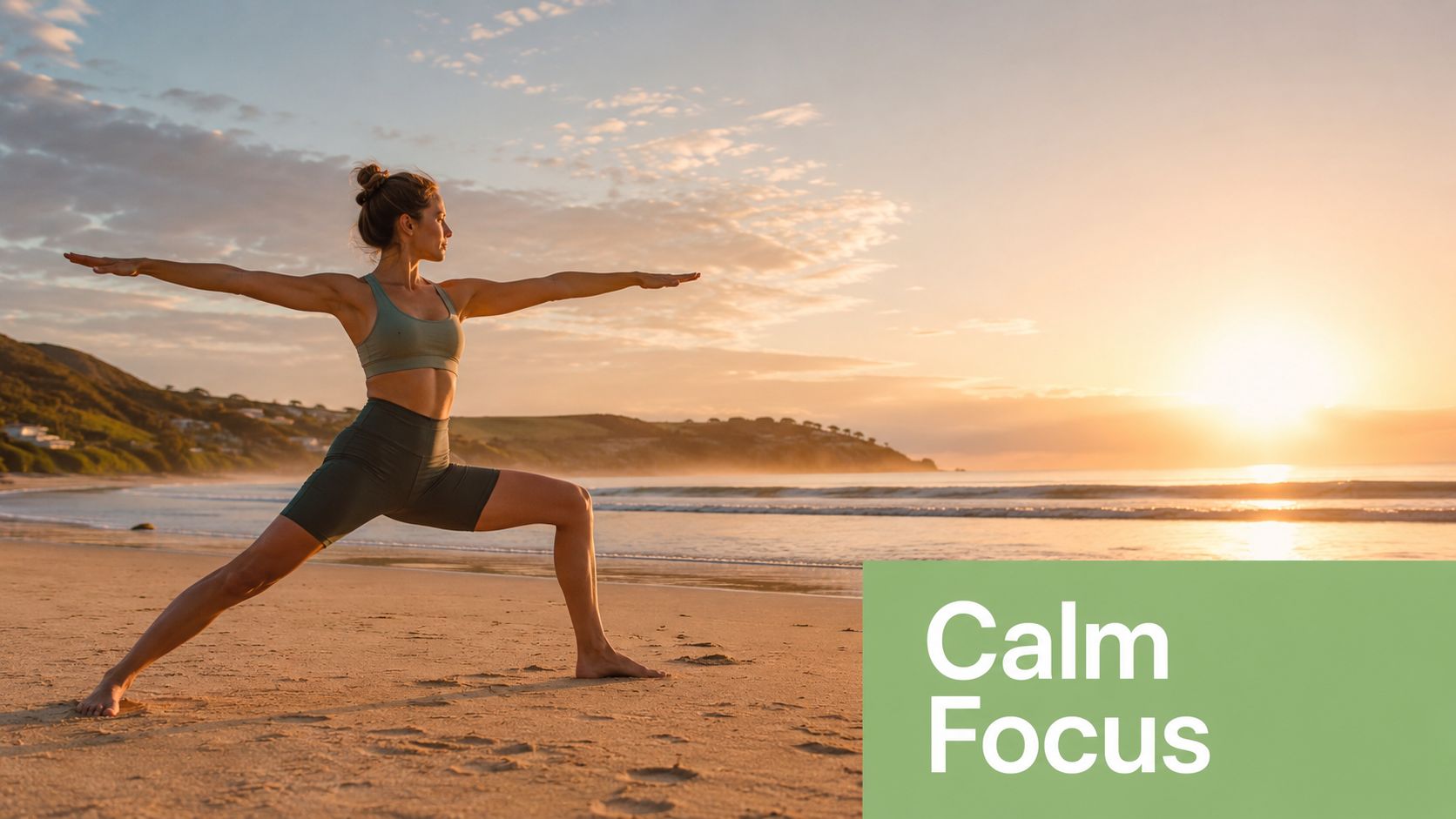 A woman performing a yoga warrior pose on a sandy beach during a beautiful golden sunset.