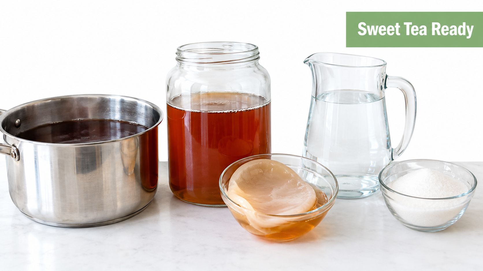 Ingredients for making kombucha including sweet tea, water, sugar, and a SCOBY on a marble surface.
