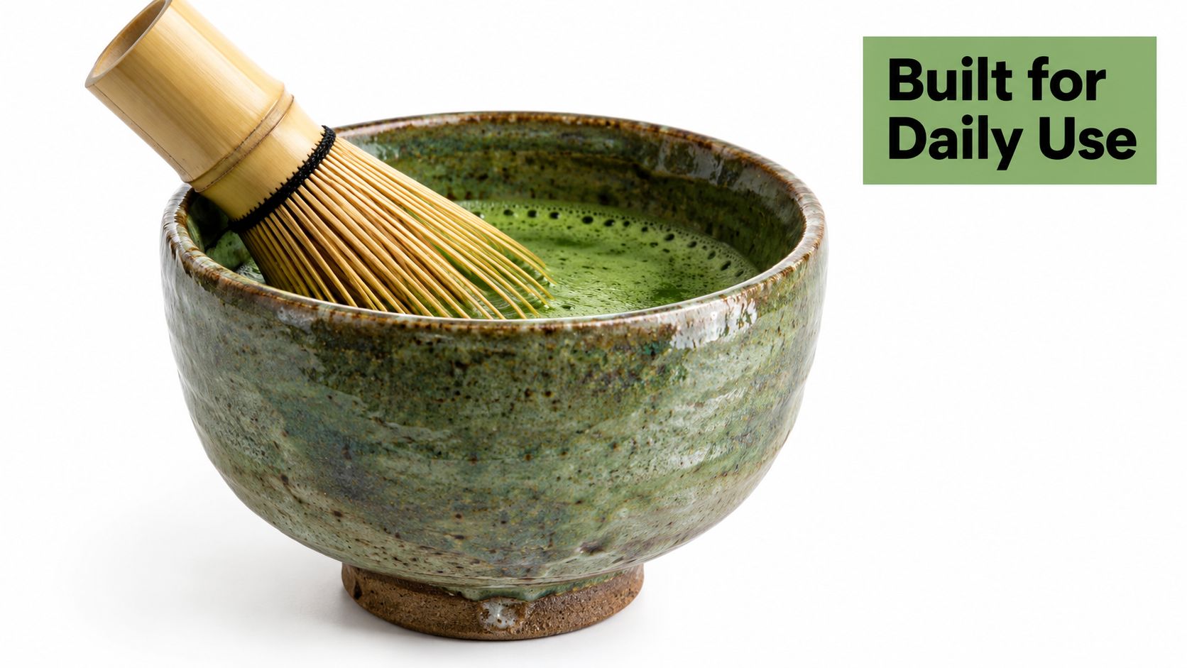 A ceramic matcha bowl containing green tea and a traditional bamboo whisk on a white background.